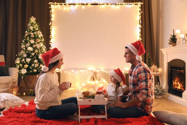 Family near video projector screen at home. Cozy Christmas atmosphere