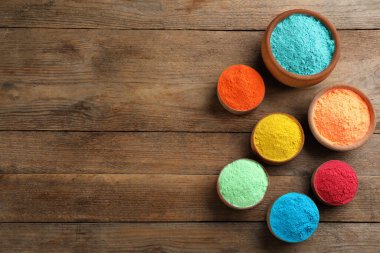 Ahşap arka planda renkli pudra boyaları, metin için yeri olan düz yataklar. Holi festivali