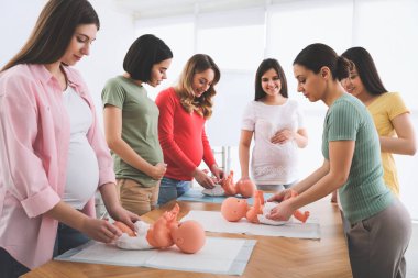 Hamile kadınlar evde hamile anneler için kurslarda kundaklamayı öğreniyorlar.
