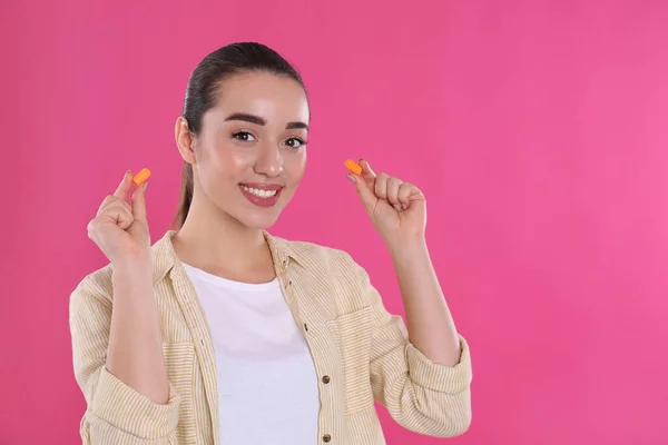 Mujer Joven Insertando Tapones Espuma Fondo Rosa Espacio Para Texto —  Fotos de Stock