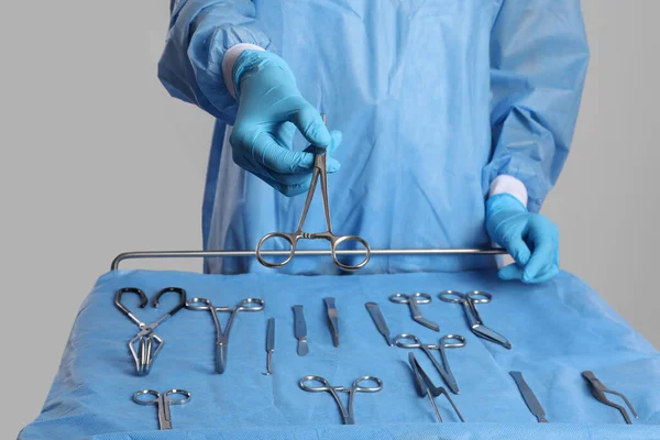 Doktor Masanın Yanında Makas Veriyor Arka Planda Farklı Cerrahi Aletler — Stok fotoğraf