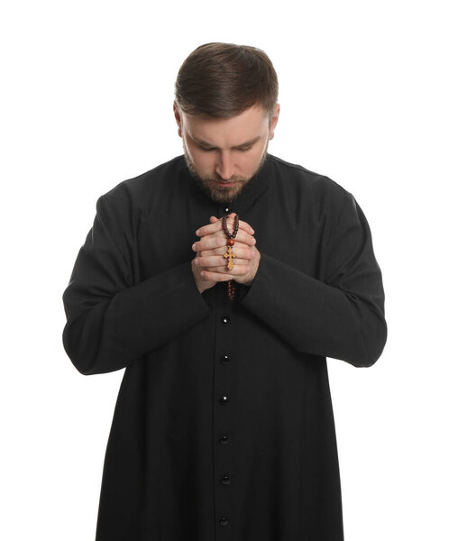 Priest with rosary beads praying on white background