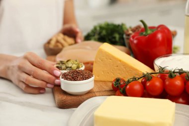 Masada farklı ürünleri olan bir kadın, yakın plan. Keto diyeti