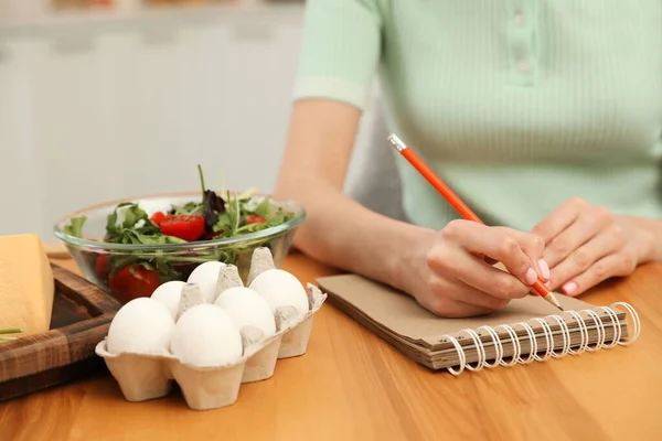 Femme Écrivant Dans Cahier Près Des Produits Table Gros Plan — Photo