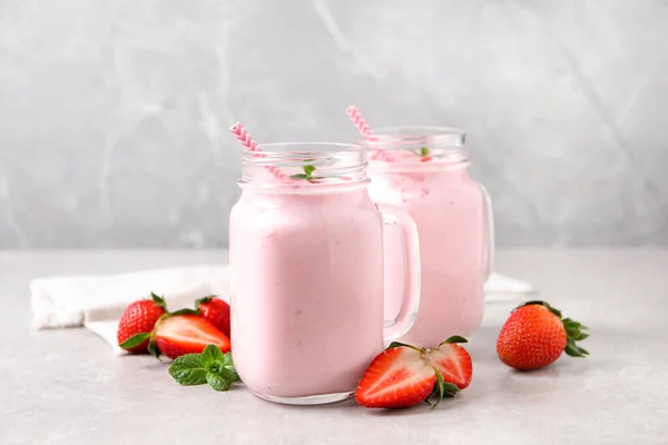 Delicious drink with strawberries on light table