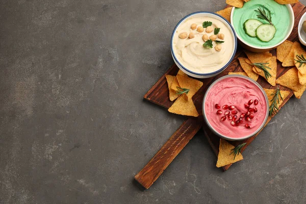 Verschillende Soorten Smakelijke Hummus Geserveerd Met Nacho Grijze Tafel Bovenaanzicht — Stockfoto