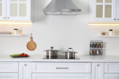 Modern ocak ve şık mobilyalarla donatılmış zarif bir mutfak.