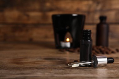 Aroma lambası ve kahve esaslı yağı ahşap masada, metin için yer var.