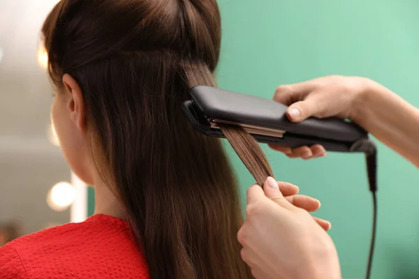 Stylist Stirare Capelli Della Donna Con Ferro Piatto Nel Salone — Foto Stock