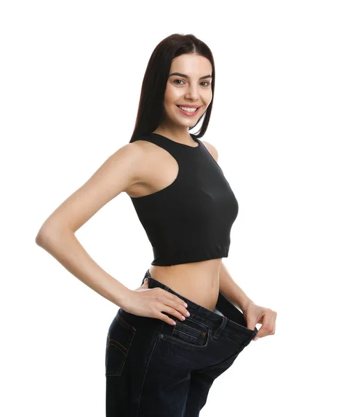 白底减肥后穿着大牛仔裤的年轻快乐女人 — 图库照片