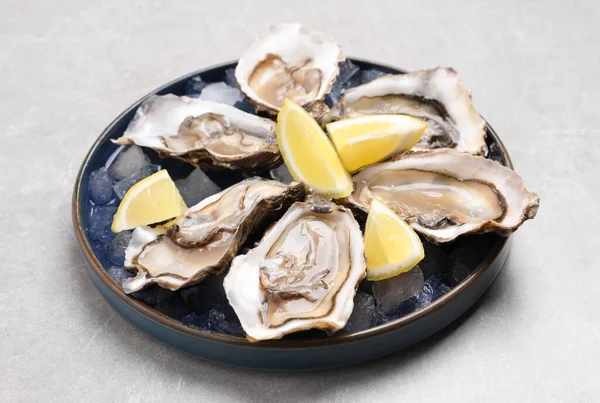 Läckra Färska Ostron Med Citronskivor Ljusgrått Bord — Stockfoto