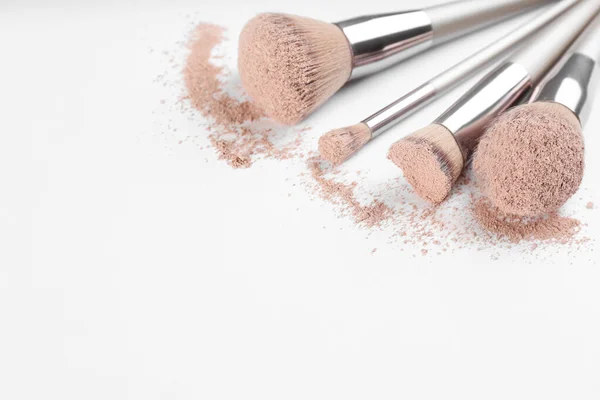 Diferentes Pinceles Maquillaje Con Producto Cosmético Triturado Sobre Fondo Claro — Foto de Stock