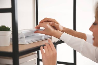 İş yerinde iş arkadaşları birbirleriyle flört ediyor, yakınlaşıyorlar.