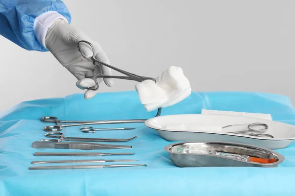 Médico Sosteniendo Fórceps Con Tejido Sobre Instrumentos Quirúrgicos Mesa Contra —  Fotos de Stock