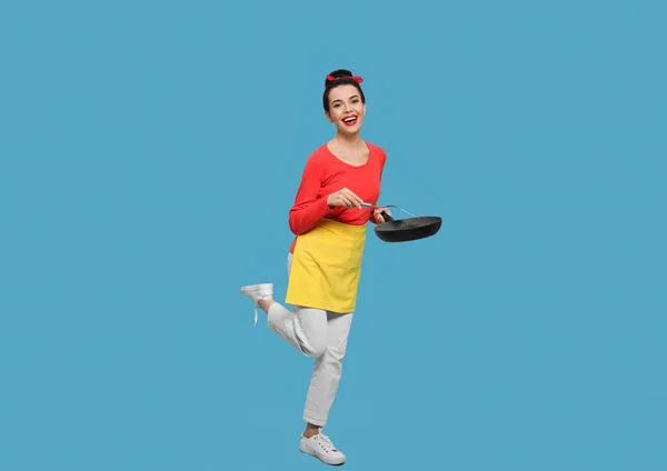 Hausfrau Mit Pfanne Und Spachtel Auf Hellblauem Hintergrund — Stockfoto