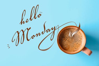 Bir fincan sıcak aromatik kahve ve cümle Merhaba Pazartesi açık mavi arka plan, üst manzara