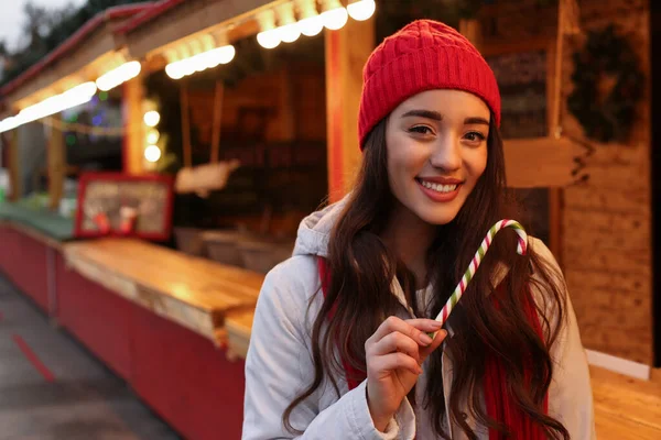 Genç bir kadın Noel fuarında vakit geçiriyor, mesaj için yer var.