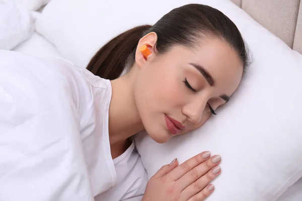 Młoda Kobieta Piankowymi Zatyczkami Uszu Śpiąca Łóżku — Zdjęcie stockowe