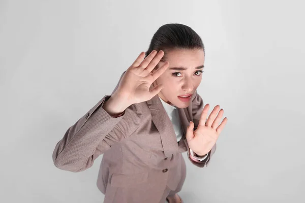 Mujer Joven Traje Evadiendo Algo Sobre Fondo Gris Claro Por —  Fotos de Stock