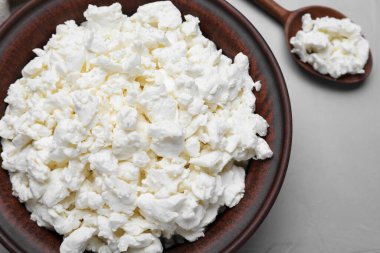 Kil kase ve kaşık, süzme peynirli gri masada, düz yatıyordu