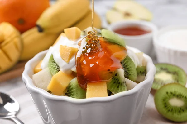 Verter Miel Una Deliciosa Ensalada Frutas Tazón Sobre Mesa Cerca —  Fotos de Stock