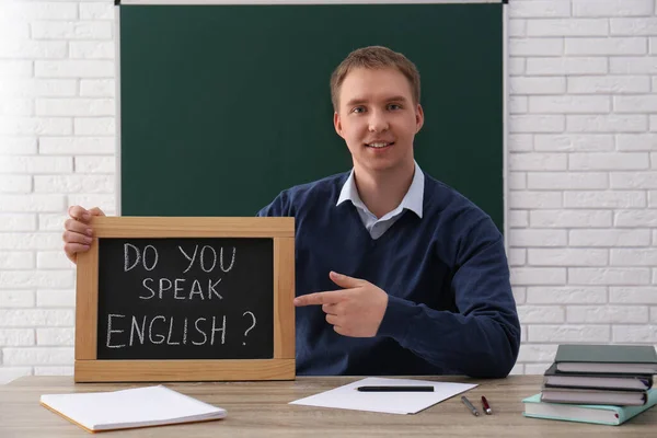 Leraar Met Klein Schoolbord Met Inscriptie Spreek Engels Aan Tafel — Stockfoto