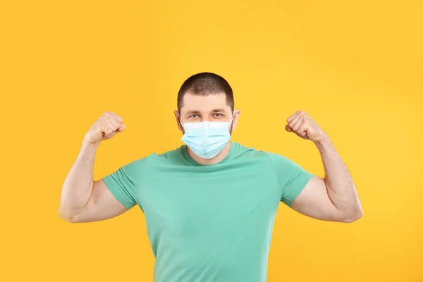 Hombre Con Máscara Protectora Mostrando Músculos Sobre Fondo Amarillo Fuerte —  Fotos de Stock