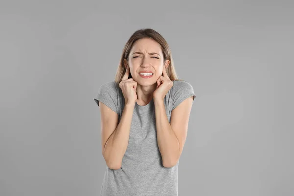 Emotionale Junge Frau Bedeckt Ihre Ohren Mit Fingern Auf Grauem — Stockfoto