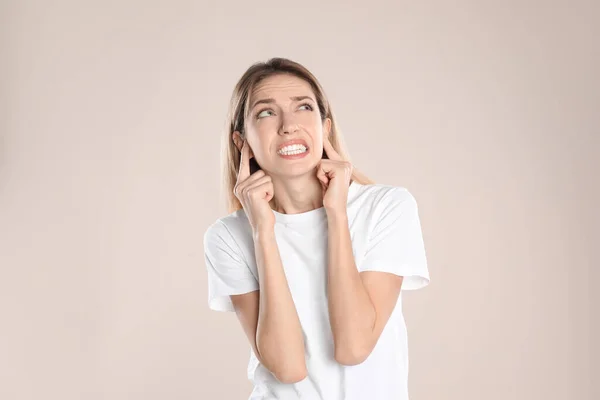 Emotional Young Woman Covering Her Ears Fingers Beige Background — Stock Photo, Image