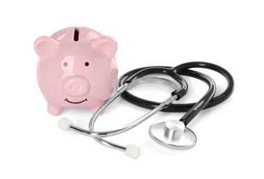 Beyaz arka planda domuz kumbarası ve steteskop.