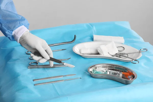 Médico Sosteniendo Bisturí Sobre Mesa Con Instrumentos Quirúrgicos Contra Fondo —  Fotos de Stock