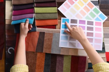 Renkli kumaş örnekleri arasından seçim yapan kadın, yakın plan.