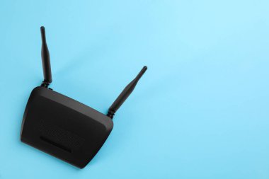 Açık mavi arka planda modern Wi-Fi yönlendirici, üst görünüm. Metin için boşluk