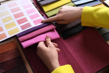 Renkli kumaş örnekleri arasından seçim yapan kadın, yakın plan.