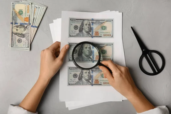 Counterfeiter Examining Sheet Paper Dollar Banknotes Grey Table Top View — Stock Photo, Image