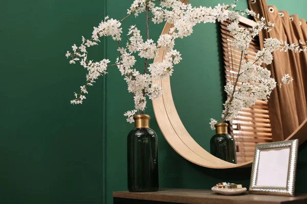室内鏡の近くの木製テーブルの上に花瓶や空の写真フレームに木の小枝を開花 — ストック写真