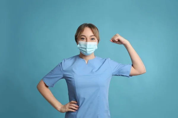 Médico Con Máscara Protectora Mostrando Músculos Sobre Fondo Azul Claro —  Fotos de Stock