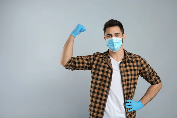 Άντρας Προστατευτική Μάσκα Και Γάντια Που Δείχνουν Μύες Ανοιχτό Γκρι — Φωτογραφία Αρχείου