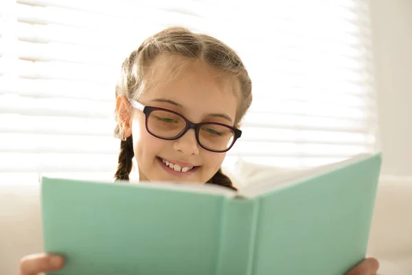 Cute Little Girl Czytania Książki Pobliżu Okna Domu — Zdjęcie stockowe