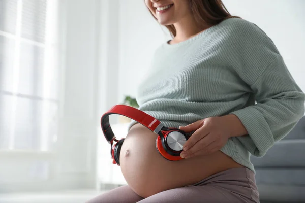 Zwangere Vrouw Met Koptelefoon Haar Buik Binnen Close — Stockfoto