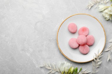 Lezzetli mochi ve açık gri mermer masa üzerinde çiçekler, düz yerde yazı için yer var. Geleneksel Japon tatlısı