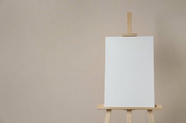 Bej arkaplanda boş tuval olan ahşap sehpa. Metin için boşluk