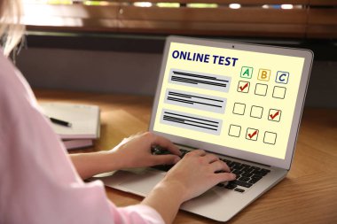 Bilgisayarı masadaki çevrimiçi test için kullanan kadın, yakın plan