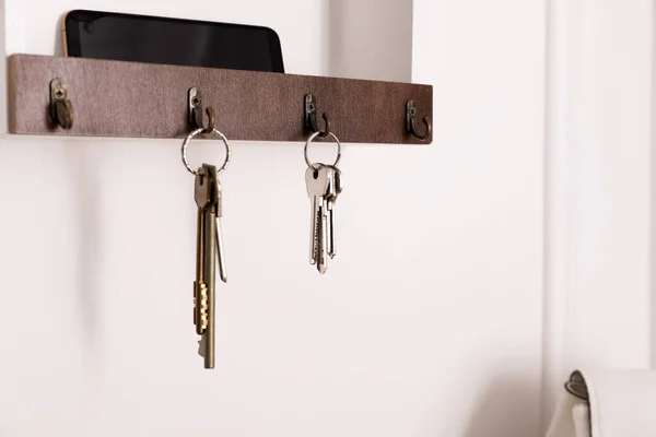 Wooden hanger for keys on white wall