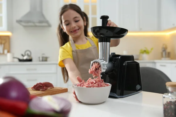 小さな女の子使用現代的な肉グラインダーでキッチン — ストック写真