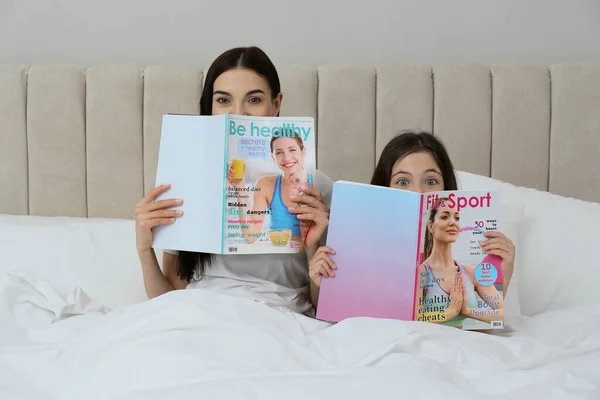 Νεαρή Μητέρα Και Κόρη Της Περιοδικά Στο Κρεβάτι Στο Σπίτι — Φωτογραφία Αρχείου