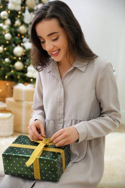 Evde yerde hediye kutusu olan bir kadın.