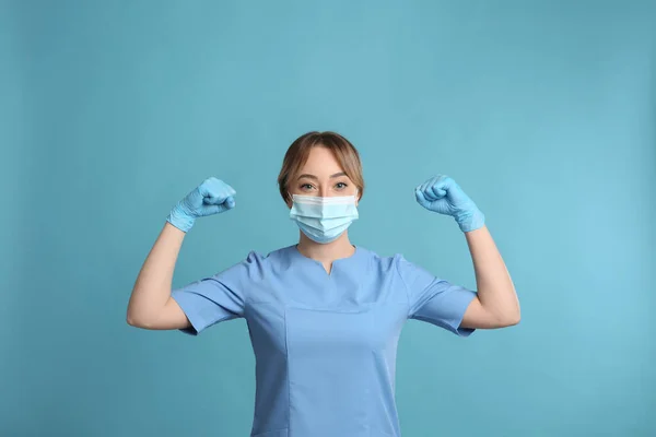 Médico Con Máscara Protectora Mostrando Músculos Sobre Fondo Azul Claro —  Fotos de Stock