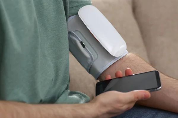 Man Checking Blood Pressure Modern Monitor Smartphone Indoors Closeup — Stock Photo, Image