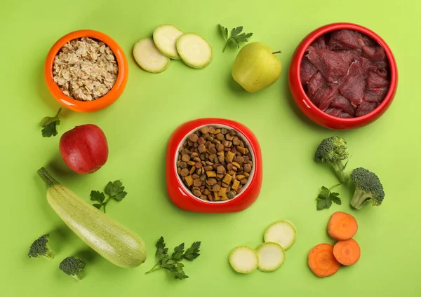 Pet food and natural ingredients on green background, flat lay